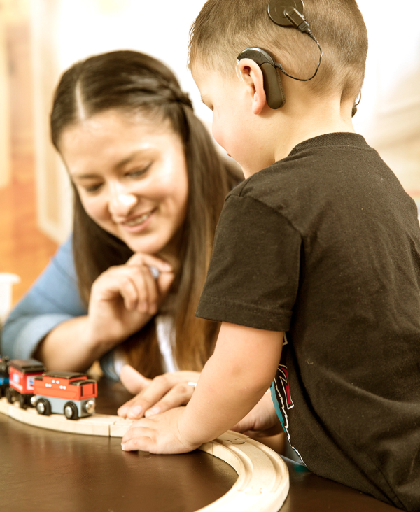 A woman and a child playing with a toy train